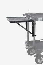 Load image into Gallery viewer, Mule Cart foldable shelf in black aluminum, attached to a production cart and holding a laptop and other film gear.