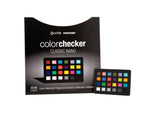Load image into Gallery viewer, The Calibrite ColorChecker Classic Nano, a small 24-patch color reference card, held between two fingers to show its compact scale for macro photography.